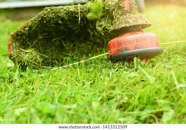 Trimmer
close up mow the grass with a lawnmower. Gardening with a brush
cutter Close-up. Lawn care with brush
cutters