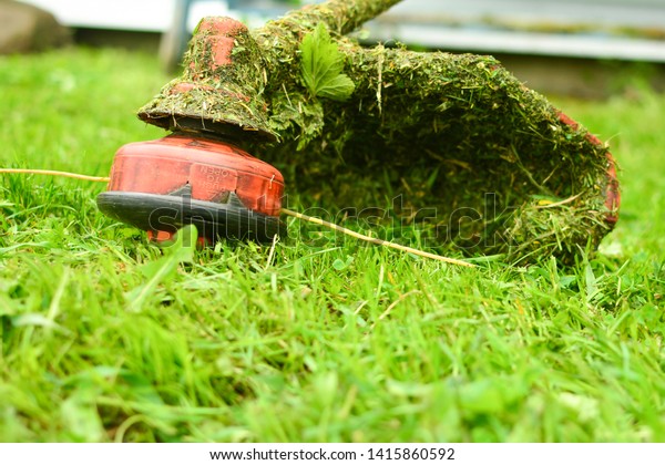 Trimmer\
close up mow the grass with a lawnmower. Gardening with a brush\
cutter Close-up. Lawn care with brush\
cutters