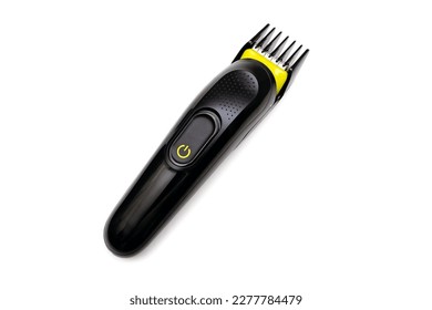 A trimmer razor for cutting and modeling hair lies on a white isolated background. Electric shaver for barbershop. Accessory for shaving a beard or hair on a person's head
