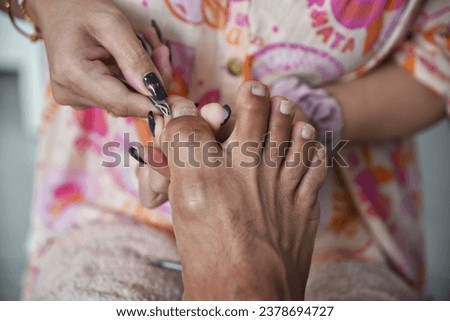 Trimming toenails, manicuring toenails, taking care of nails and feet By a female beautician cutting toenails of male customers in beauty salons