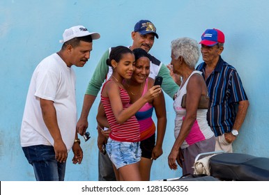 Trinidad, Cuba - April 7, 2016: Cuban Family Of Several Generation Making Video Call On Their Cell Phone And Smiling. Internet Access In Cuba Is Limited.