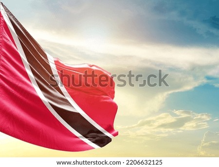 Trinidad and Tobago national flag waving in beautiful sky.