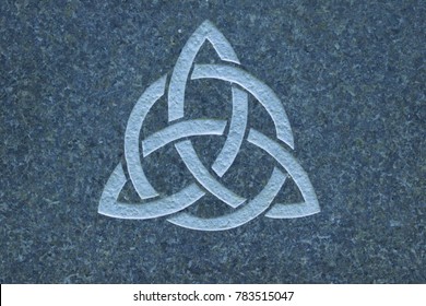 Trinity Knot On Granite Stone Surface. The Triquetra Is Found On Runestones In Northern Europe And On Early Germanic Coins. The Symbol Has Been Interpreted As Representing The Christian Trinity.