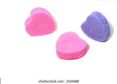 A Trio Of Candy Hearts On A White Background