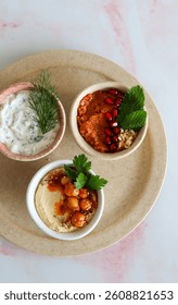 Trio of middle eastern dips, different colours and flavours on a white neutral ceramic background