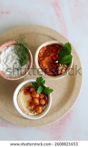 Trio of middle eastern dips, different colours and flavours on a white neutral ceramic background