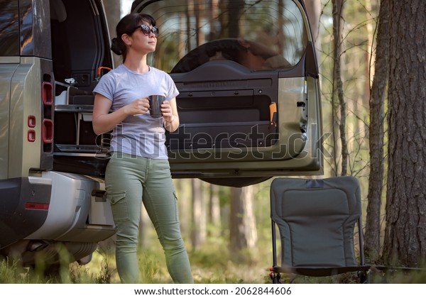 Trip in the nature by car\
family vacation on the weekend. Woman traveller enjoy coffee\
time.