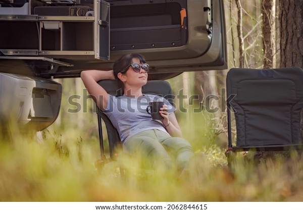 Trip in the nature by car
family vacation on the weekend. Woman traveller enjoy coffee
time.