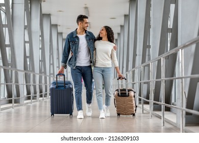 Trip Together. Happy Young Arab Spouses Walking With Luggage At Airport Terminal, Romantic Middle Eastern Couple Embracing And Smiling To Each Other While Going To Boarding Gate, Copy Space - Shutterstock ID 2126209103