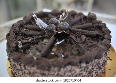 Triple Chocolate Cake Frosted On The Sides With Hand Crafted Chocolate Frosting Decorations On Tops.