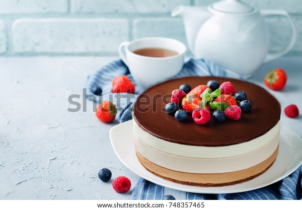 Triple chocolate mousse cake decorated\
with fresh berries. toning. selective\
focus