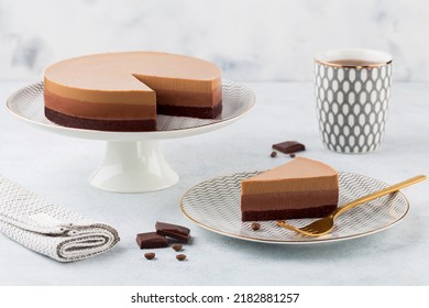 Triple Chocolate Mousse Cake On A Cake Stand On White Background