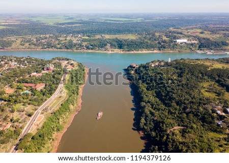 Triple Frontier, tri-border junction of Paraguay, Argentina and Brazil. Iguazú and Paraná rivers confluence. Cities Ciudad del Este; Puerto Iguazú, Foz do Iguaçu. Aerial drone photo. Two color river