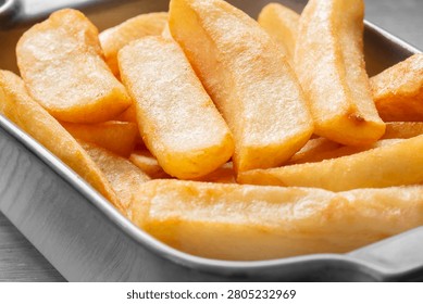 Tripled cooked fried chips in a stoneware dish. Traditional British fried food concept. Edited with selective colour