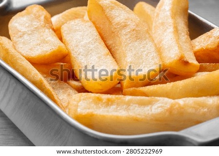 Tripled cooked fried chips in a stoneware dish. Traditional British fried food concept. Edited with selective colour