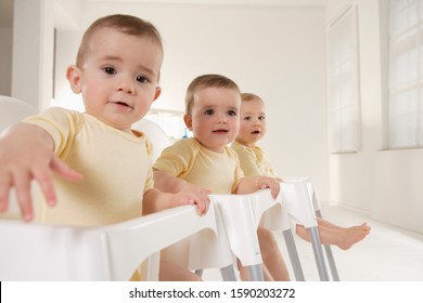 Triplet Babies Sitting In High Chairs