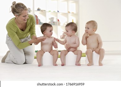 Triplet Babies Sitting On Potty Chairs