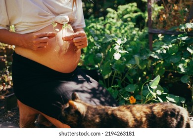 It's Triplets! Pregnant Woman In The Garden With Triplets In Her Belly, Holding Three Sprouted Plants