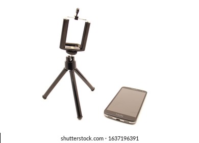 Tripod And Nearby Smartphone Lying Isolated On A White Background