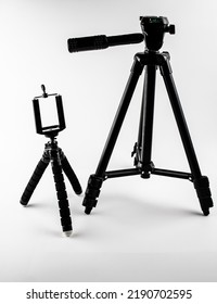 The Tripods For The Camera, Camcorder On A White Background. Tripod For Smartphone And Camera.