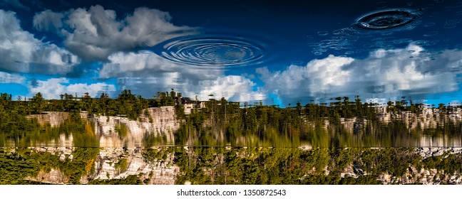 Trippy Upside Down Landscape Of Lake With Ripples And Rock Face 