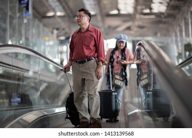 The trips. Seniors are travelling. Standing in the airport. Escalator. Performs elderly couple in retirement in the airport. Experienced travel tickets booking airline. waiting and delays - Powered by Shutterstock