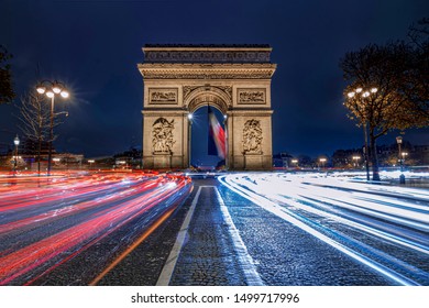 Triumph Arc, Arc De Triomphe In French,  Place At The Blue Hours Crowded With Car Traffic, Paris, France
