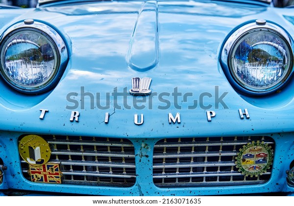 Triumph\
sports car, front view of a blue old dirty classic car from british\
production in Hildesheim, Germany, May 21,\
2022
