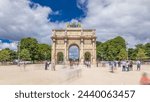 Triumphal Arch (Arc de Triomphe du Carrousel) timelapse hyperlapse at Tuileries gardens in Paris, France. Tourist walking around at summer day with blue cloudy sky. Walking toward