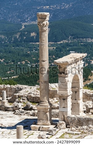 Triumphal arch and honorary column at Upper Agora in ancient city of Sagalassos. Cover page. Scenic landscape of Pisidia at background. Aglasun, Budur, Turkey