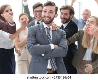 Triumphant Group Of Staff Congratulating Their Leader