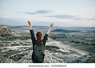 triumphant hiker celebrates conquering mountain peak with arms raised in victory - Powered by Shutterstock