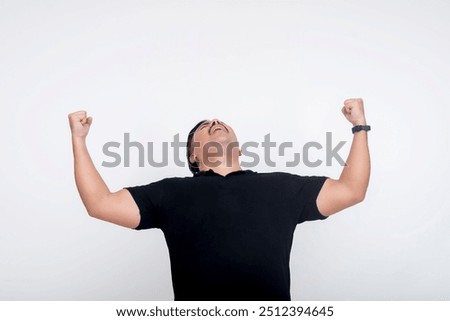 A triumphant man looking up and pumping both fists in victorious ecstasy. Set against a white background.