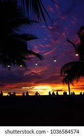 Trobical vibes during sunset with people and palmtrees in silhouettes at Manila Baywalk