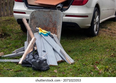 A Trolley With Cut Boards And A Car With Open Boot Full Of Construction Material