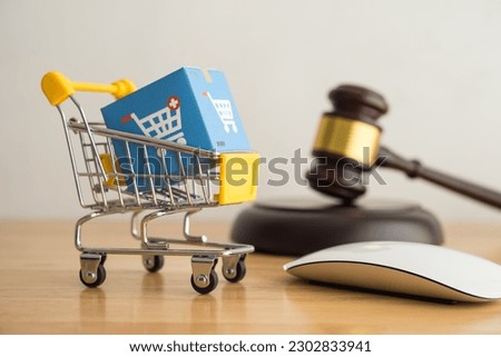 Trolley, mouse, online shopping boxes and hammer judge on wooden background. Consumer rights and responsibilities to safety, customer protection in online shopping e-commerce, commercial law concept
