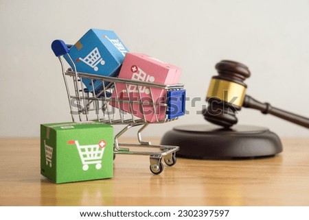 Trolley, online shopping boxes and hammer judge gavel on wooden background. Consumer rights and responsibilities to safety, customer protection in online shopping e-commerce, commercial law concept.