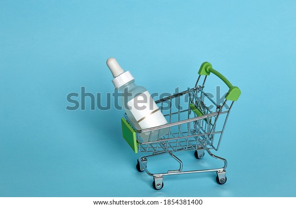 trolley from the\
supermarket. Cosmetic make-up product, face serum. the concept of\
fewer purchases driving consumer behavior, the effect of online\
shopping, business\
reduction.