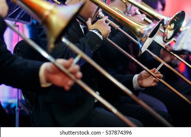 A Trombone Section Playing Together In A Traditional Big Band Jazz Ensemble. Selective Focus On The Foreground Trombone.