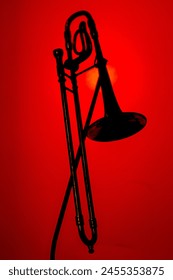 A trombone silhouette with a red background.