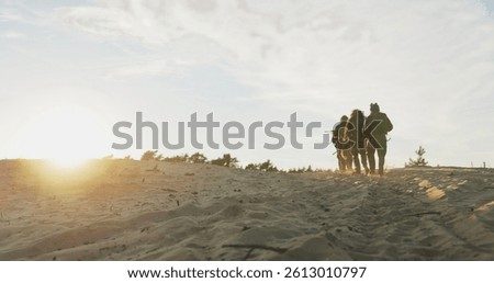 Troops move in formation across the sandy training ground, their military boots leaving deep tracks as they patrol the area, surveying the surroundings for strategic advantage.