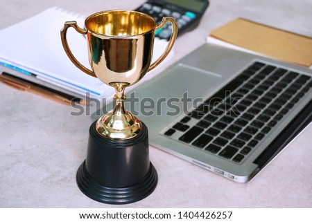 Trophy decorate on working table,acheive concept.