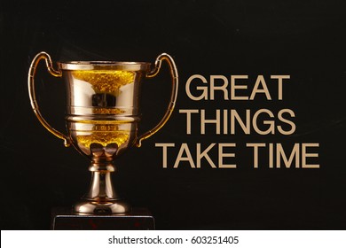 trophy in front of blackboard with text great things take time