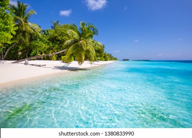 Tropical beach background as summer landscape with beach swing or hammock and white sand and calm sea for beach banner. Perfect beach scene vacation and summer holiday concept. Boost up color process 