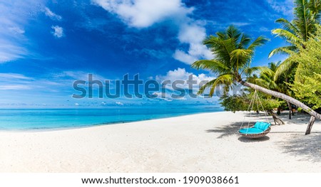 Tropical beach background as summer relax landscape with beach swing or hammock and white sand and calm sea for beach template. Amazing beach scene vacation and summer holiday concept. Luxury travel