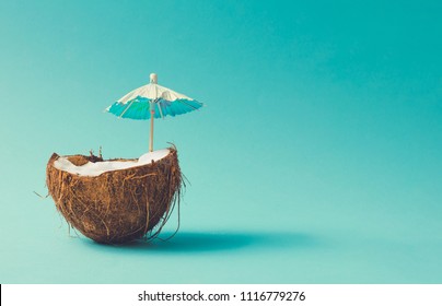 Tropical Beach Concept Made Of Coconut Fruit And Sun Umbrella. Creative Minimal Summer Idea.