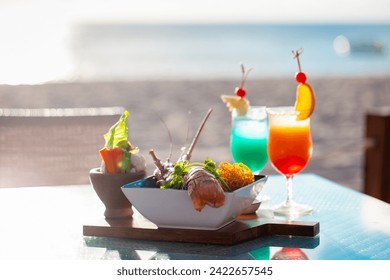 Tropical beach dining, fresh salad and colorful cocktails with ocean view. Vacation and leisure - Powered by Shutterstock