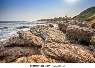 Tropical Beach With Palm Tree And Wave Crashing On Rocks In Ghana, West Africa 