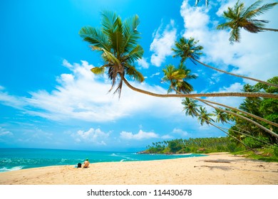 Tropical Beach In Sri Lanka. Young Woman Sitting On The Sand.