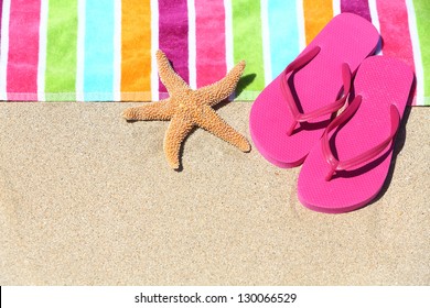Tropical beach vacation holiday and travel concept with a colourful striped beach towel and vibrant pink sandal flip flip thongs on pristine sand with a starfish at an idyllic coastal beach resort. - Shutterstock ID 130066529